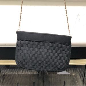 Black coin purse with gold colored strap.